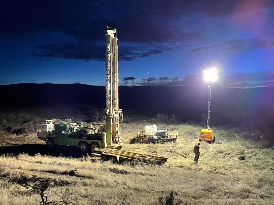 American Drilling rig working at a well drilling site near dusk